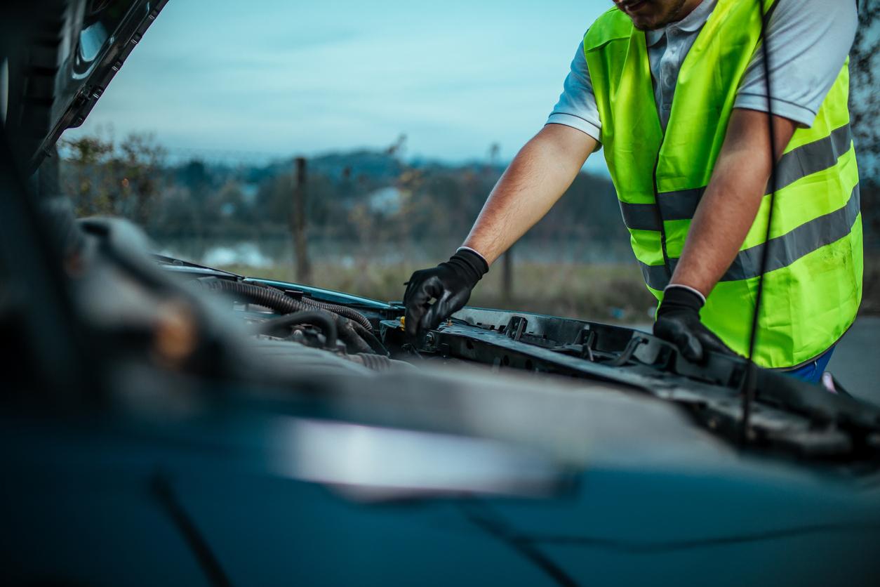 Man fixing broken down car